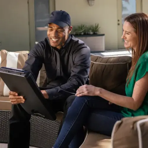 A Ja-Roy pest control technician discusses a residential extermination quote with a happy customer