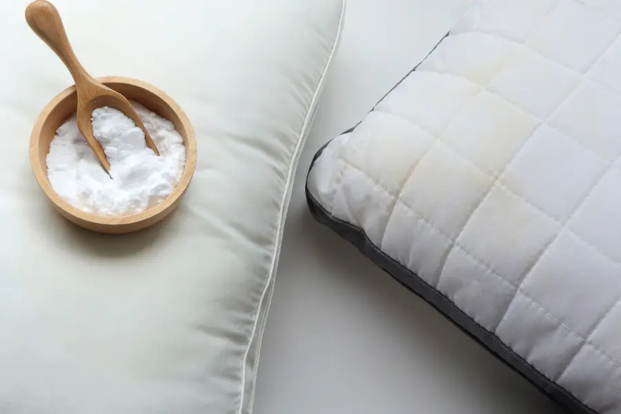 Baking soda in a wooden bowl next to a pillow after discovering a bed bug infestation