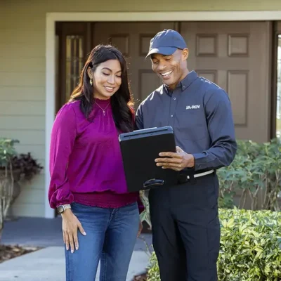 Tech speaking with customer in front of a house | Ja-Roy Pest control serving in Covington LA