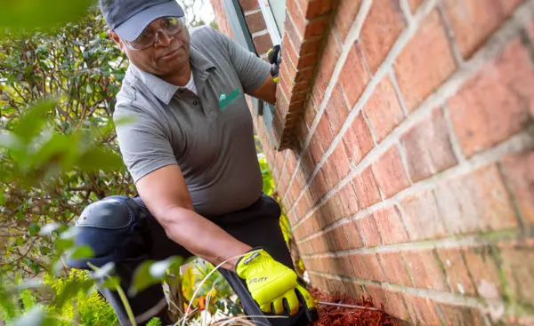 A Ja-Roy Pest Control technician checks the foundation of a Baton Rouge home for pest activity