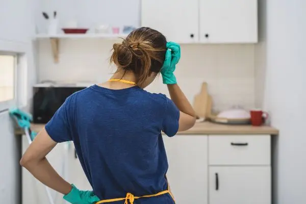 Person in a kitchen in cleaning gear - Keep pests away from your home with Ja-Roy Pest Control in Louisiana